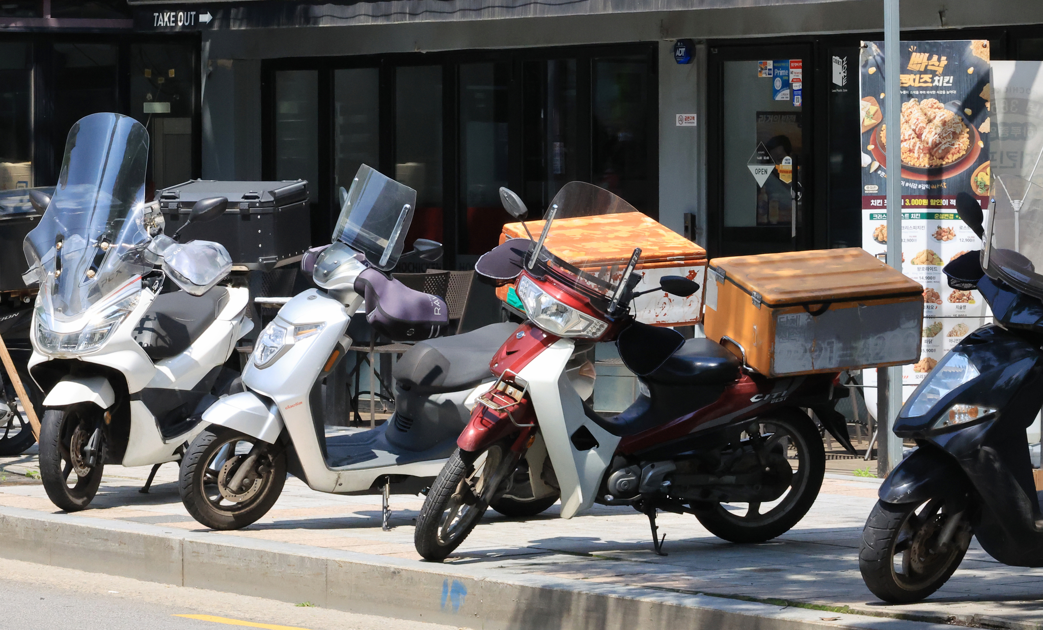 Motorcyles are tightly parked in front of a traditional market in Seoul on May 25. The license plate is stuck at the rear end of the vehicle. [YONHAP]