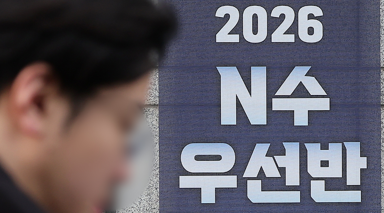 A passerby walks past a banner recruiting retakers for the 2026 College Scholastic Ability Test in central Seoul on Jan. 6. [NEWS1]