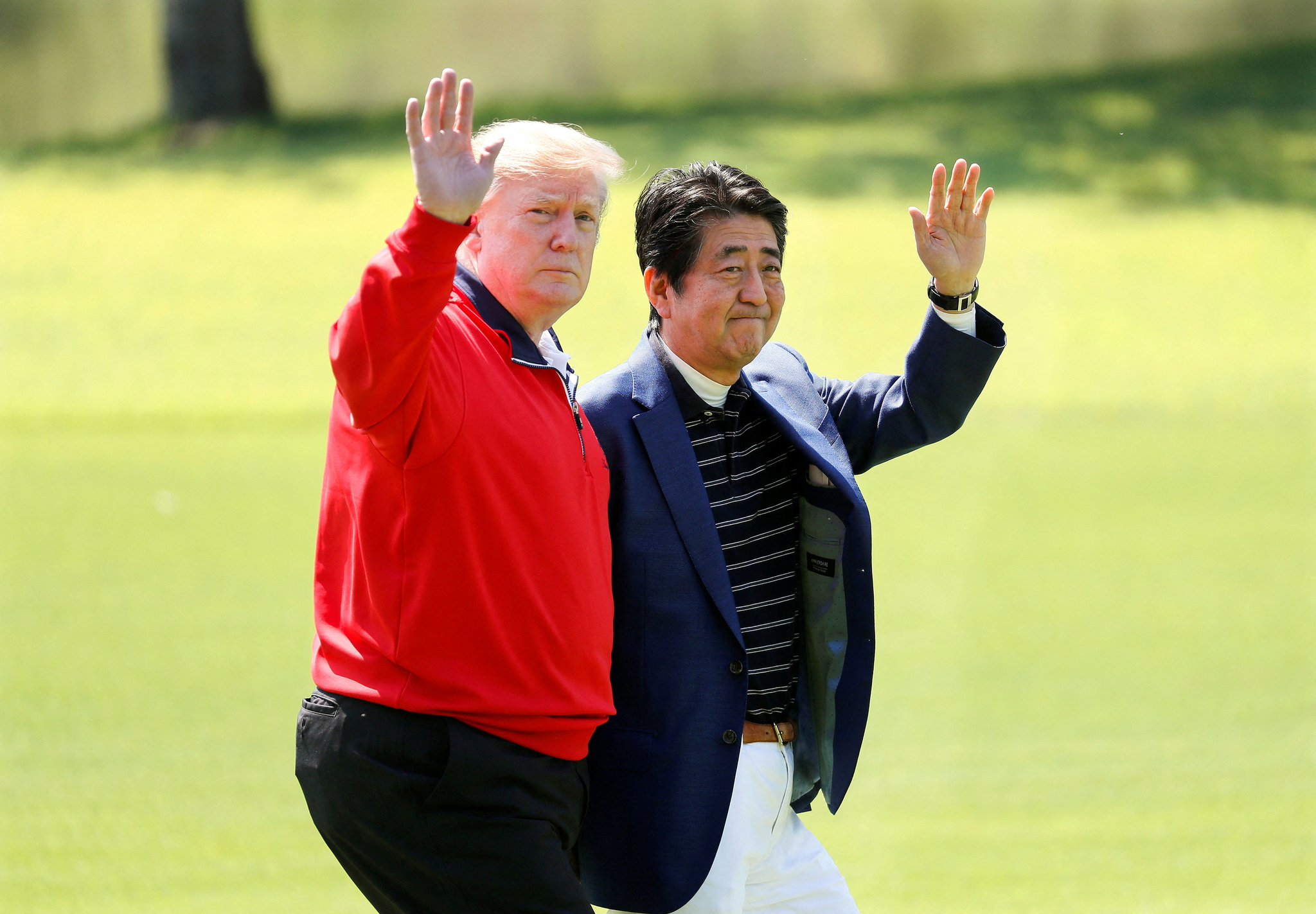 U.S. President Donald Trump and Japanese Prime Minister Shinzo Abe wave on the way to the course to play golf at Mobara Country Club in Mobara, Chiba Prefecture, east of Tokyo, Japan May 26, 2019. [REUTERS/YONHAP]