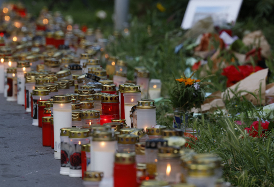 Flowers and candles are left at a makeshift memorial site in front of the school the day after 10 people died in a school shooting, on June 12, 2025, in Graz, southeastern Austria. [AFP/YONHAP]
