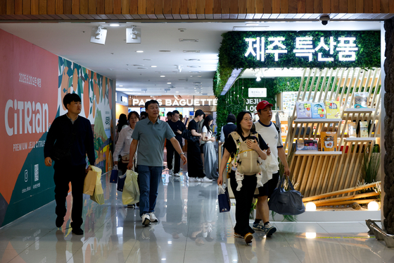 Tourists purchase items at the passenger-preferred brand street set up at Korea Airports Corporation Jeju International Airport on June 12. [JOINT PRESS CORPS]