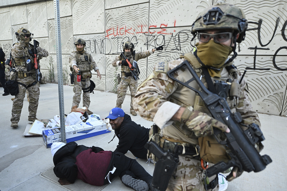 Agents from U.S. Customs and Border Protection surround demonstrators during protests in Los Angeles on June 12. [AP/YONHAP]