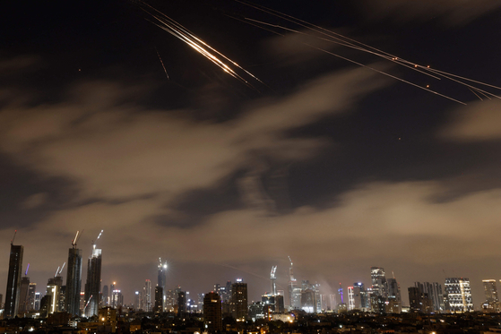 Israeli air defence systems intercept Iranian missiles over the Israeli city of Tel Aviv early on June 15. Air raid sirens and booms rang out in Jerusalem and Tel Aviv early on June 15, AFP journalists said, as Israel and Iran exchanged fire for a third day. [AFP/YONHAP]