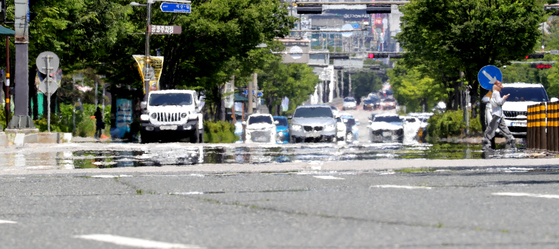 A shimmering heat haze rises above Hyoja-ro in Jeonju, North Jeolla, on June 11, as unrelenting summer heat continued to blanket the region. Korea issued its first heat advisory of the summer on June 15. [NEWS1] 