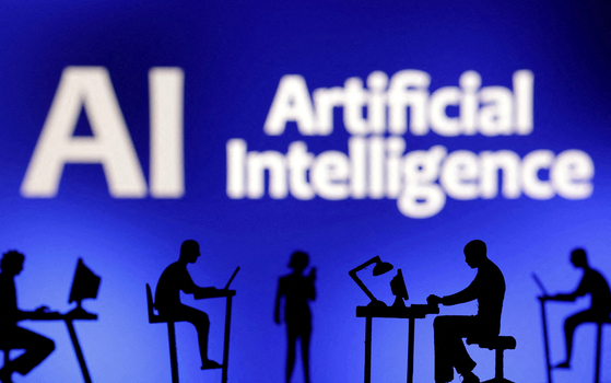 Figurines with computers and smartphones are seen in front of the words ″Artificial Intelligence AI″ in this illustration taken on Feb. 19, 2024. [REUTERS/YONHAP]