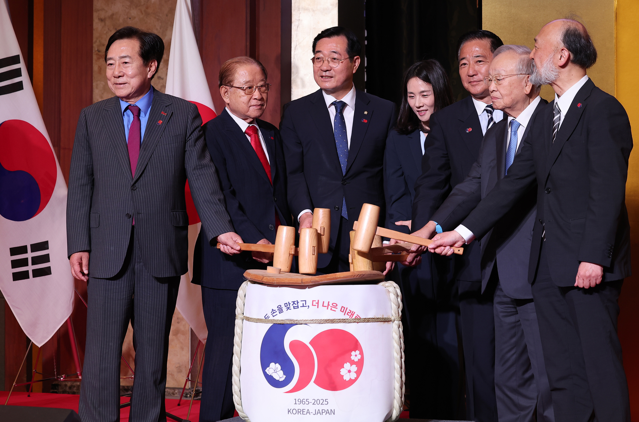 Guests take part in a traditional Japanese kagami biraki ceremony, or breaking open of the lid of a sake barrel with wooden mallets to celebrate important milestones, during a reception marking the 60th anniversary of Korea-Japan diplomatic normalization at Lotte Hotel in central Seoul on June 16. [NEWS1]