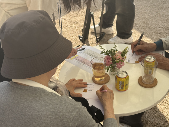 Older adults participating in Jongno District's matchmaking event write down their first and second choices after one-on-one conversations at Mugyewon in central Seoul on June 12.[CHO JUNG-WOO]