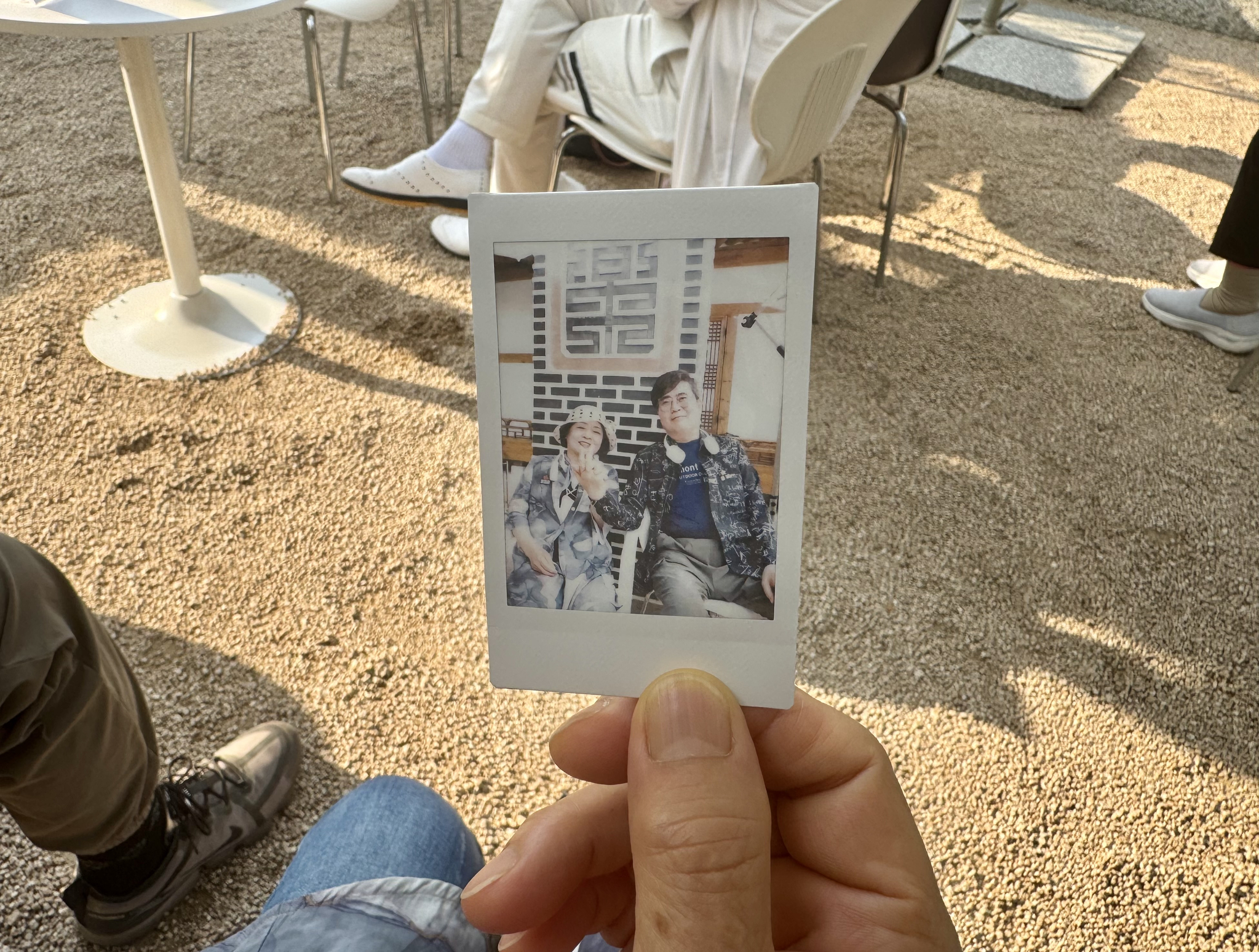 Kang Pil-soon, 70, who goes by the nickname Oriole, left, and Yubi hold hands in a Polaroid photo taken to celebrate their match during a matchmaking event for older adults at Mugyewon in Jongno District, central Seoul, on June 12. [CHO JUNG-WOO] 