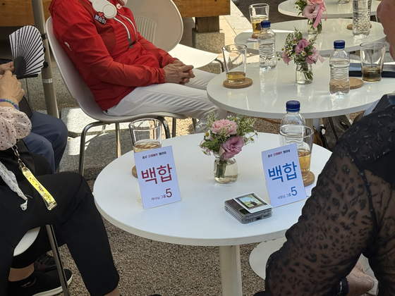 Older adults sit at a table named after the flower lily during a matchmaking event hosted by Jongno District at Mugyewon in central Seoul on June 12. [CHO JUNG-WOO]