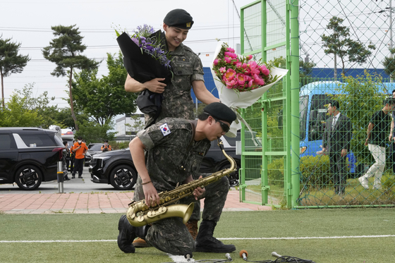 K-pop band BTS members RM, bottom, and V on June 10, the day they were discharged from mandatory military service in Chuncheon, Gangwon [AP/YONHAP]