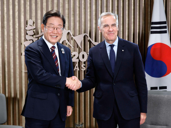 President Lee Jae Myung, left, shakes hands with Canadian Prime Minister Mark Carney on the margins of the G7 summit in Kananaskis in Canada on June 17. [JOINT PRESS CORPS]