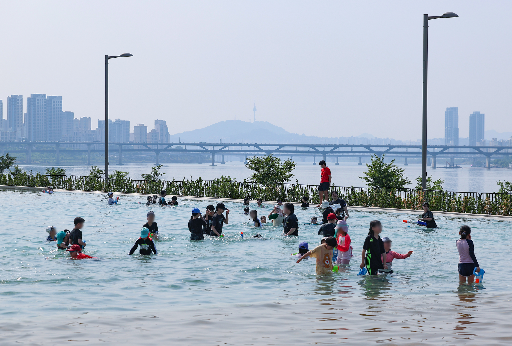 Visitors play in the water at a pool in Jamsil Hangang Park in Songpa District, southern Seoul, on June 19, 2024. [YONHAP] 