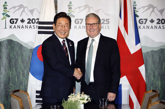 President Lee Jae Myung, left, shakes hands with British Prime Minister Keir Starmer at the G7 summit in Kananaskis, Alberta, in Canada on June 17. [JOINT PRESS CORPS]