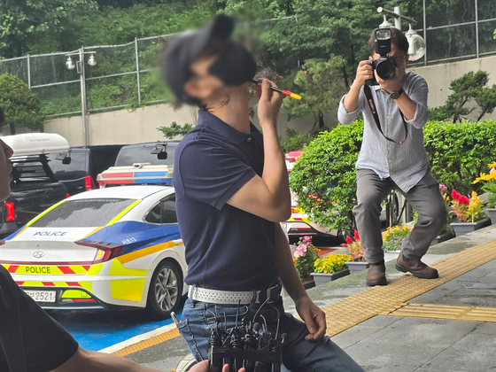 The father of a medical student who was allegedly fatally stabbed by her boyfriend in 2024 mimics the stab wounds inflicted on the victim in front of Seocho Police Precinct on June 20. [YONHAP]