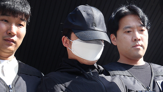 A medical student surnamed Choi, accused of murdering his girlfriend in May 2024, is escorted from the Seocho Police Precinct in southern Seoul to prosecutors on May 14, 2024. He allegedly fatally stabbed his girlfriend on the rooftop of a building near Gangnam Station a week prior. [NEWS1]