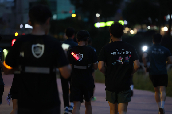The Seoul Running Patrol, a joint team of Seodaemun Police Precinct officers and members of local running crews, conducts its first patrol along Hongje Stream in Seodaemun District, western Seoul, on June 19. [YONHAP]
