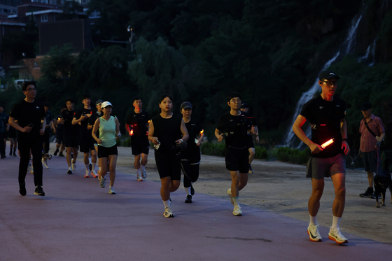 The Seoul Running Patrol, a joint team of Seodaemun Police Precinct officers and members of local running crews, conducts its first patrol along Hongje Stream in Seodaemun District, western Seoul, on June 19. [YONHAP]