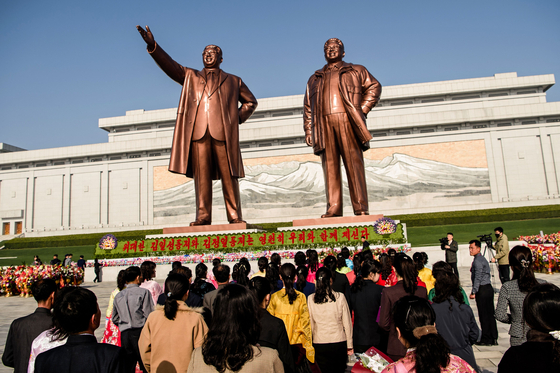  People pay tribute to the statues of late North Korean leaders Kim Il Sung and Kim Jong Il at Mansu Hill in Pyongyang on April 15 to mark the 113th birth anniversary of late leader Kim Il Sung, celebrated as the ″Day of the Sun″. [AFP/YONHAP]