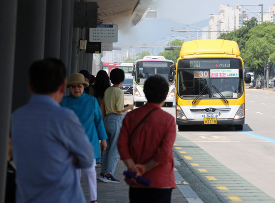 Citizens wait for city buses at a bus stop in Gwangcheon-dong, Seo District, Gwangju on June 18. [YONHAP] 