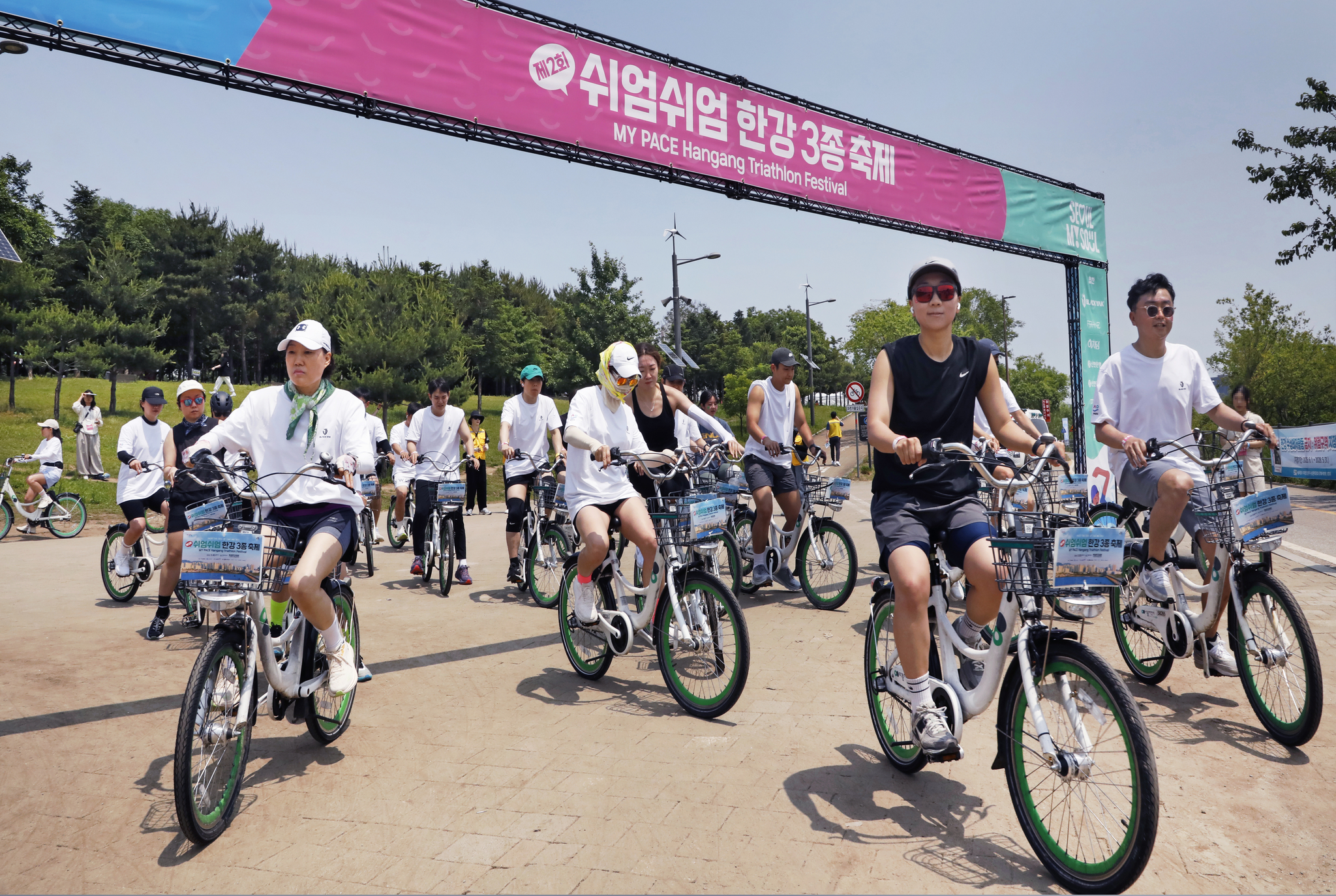 Participants in the Seoul city government's triathlon event ride bicycles in Ttukseom Hangang Park in eastern Seoul on May 30. [PARK SANG-MOON]