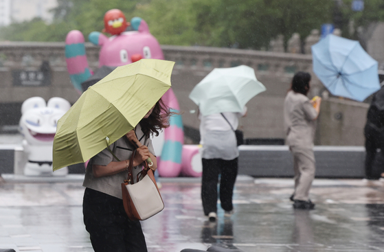 A person with an umbrella walks in the rain in Seoul on June 20. [YONHAP]