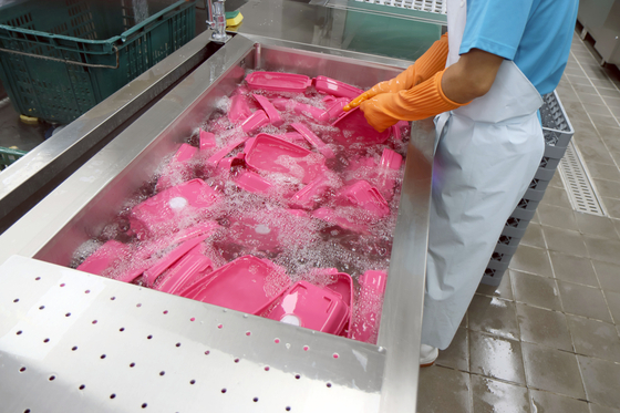 A kitchen worker washes reusable containers at a baseball stadium in Seoul [SEOUL METROPOLITAN GOVERNMENT]