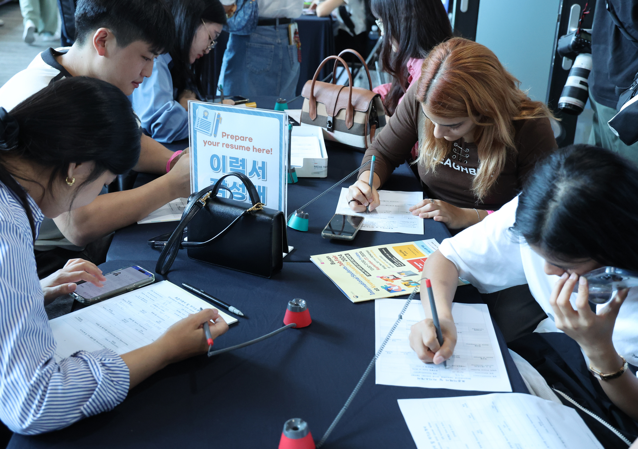 International students fill in application forms at a job fair held in Busan on Sept. 27, 2024. [YONHAP]