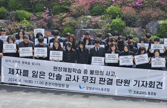 Attendees hold up slogans during a protest rally calling for the acquittal of a teacher who was held responsible for the death of a student during a field trip in 2022, outside the Chuncheon District Court in Gangwon on April 16, 2024. [YONHAP] 