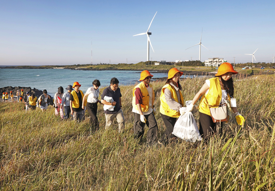 Participants of the Global Youth in Jeju Net Zero Tour take part in a clean-up activity on Gimnyeong beach on June 4. [KOREA JOONGANG DAILY]