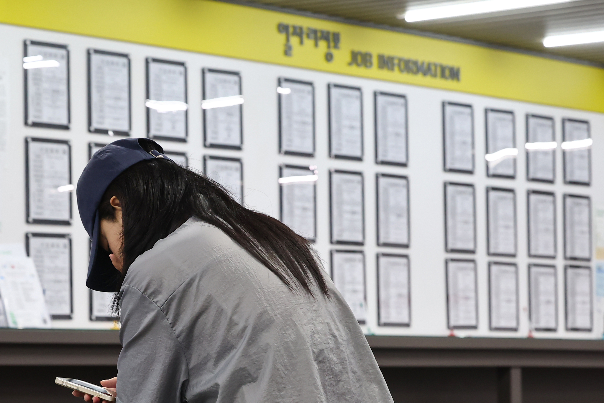 A job seeker waits for a consultation session in front of a board displaying notices at an employment center in Mapo District, western Seoul. [YONHAP] 