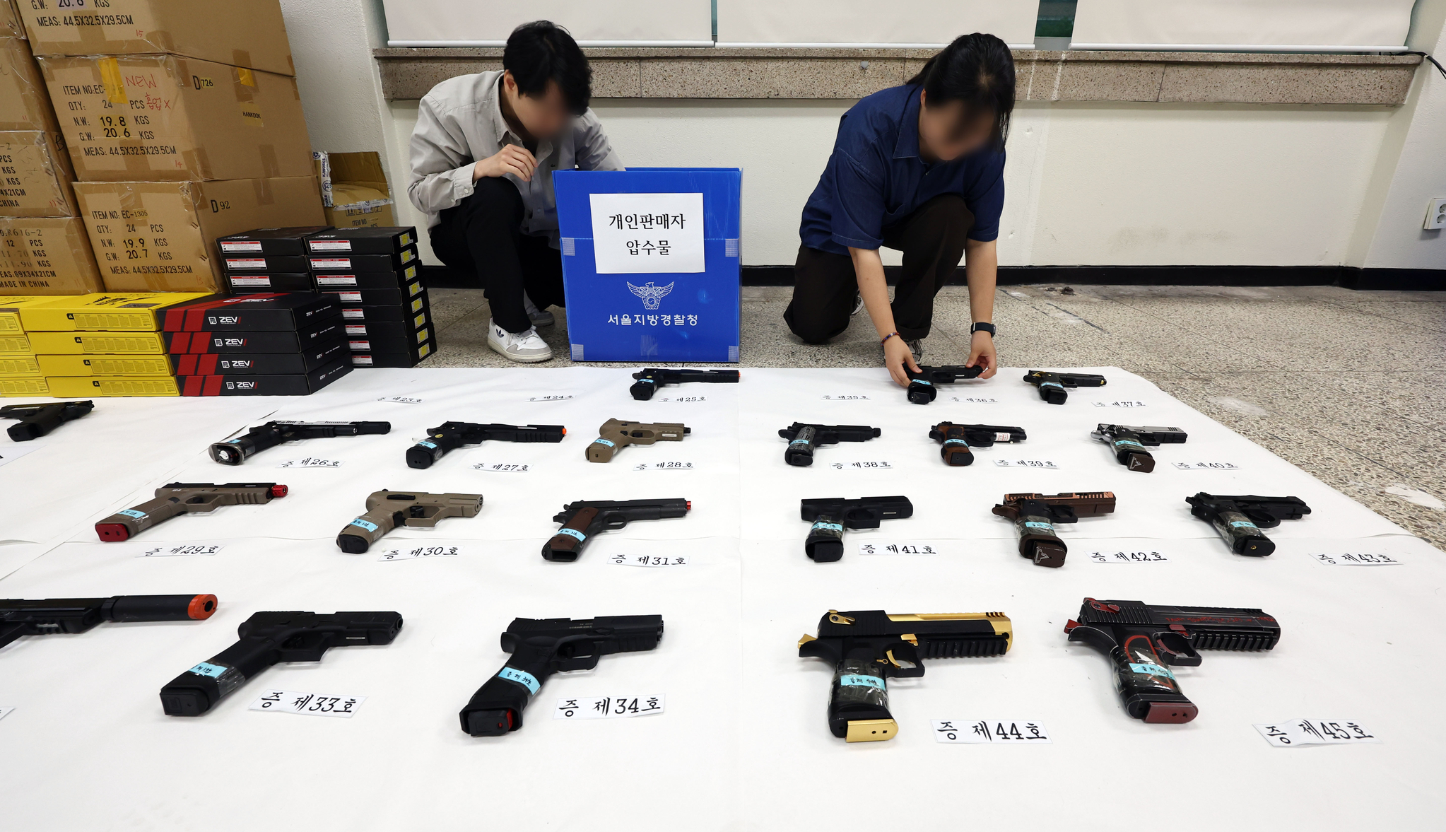 Investigators from the Seoul Metropolitan Police Agency’s vice crimes unit organize confiscated items after arresting an illegal mock firearm distributor and a private seller in eastern Seoul on June 25. [YONHAP]