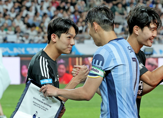 Team K League's Yang Min-hyuk, left, shakes hands with Tottenham Hotspur captain Son Heung-min before a Coupang Play Series match at the Seoul World Cup Stadium in western Seoul on July 31. [NEWS1] 