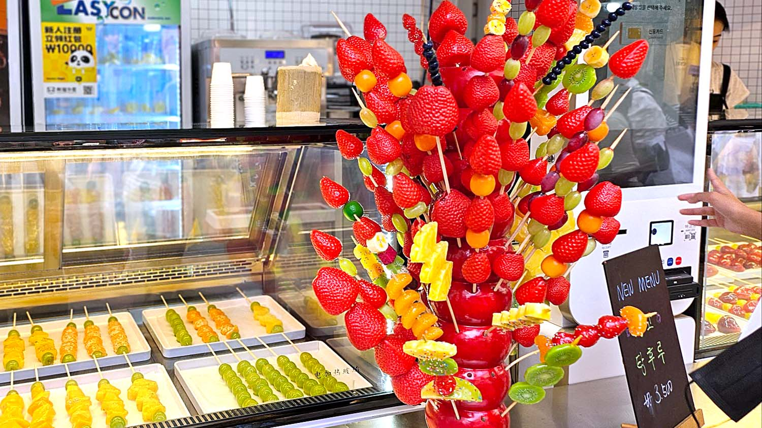 Tanghulu, a traditional Chinese dessert created by skewering assorted fruits coated with a layer of sugary syrup, is on display at the store in Mapo District, western Seoul, on Oct. 10. [JOONGANG PHOTO]