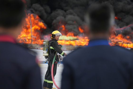 A firefighter stands by near burning illegal narcotics during a destruction ceremony to mark International Day against Drug Abuse and Illicit Trafficking, on the outskirts of Yangon, Myanmar, June 26. [AP/YONHAP]