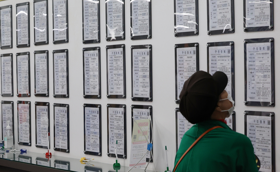 A job seeker reads job notices at an employment center in Mapo District, western Seoul, on June 26. [YONHAP] 