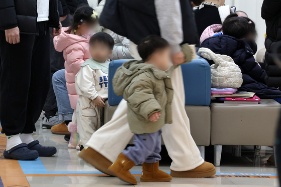 Children and their parents wait for treatment at a pediatric hospital in Seoul on Jan. 13. [NEWS1] 