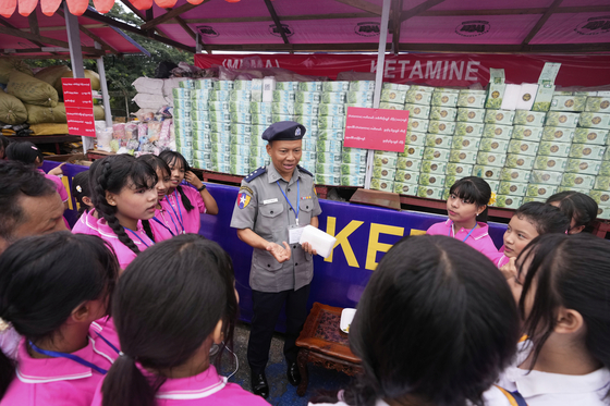 A police officer explains illegal narcotics to students during a destruction ceremony to mark International Day against Drug Abuse and Illicit Trafficking, on the outskirts of Yangon, Myanmar, June 26. [AP/YONHAP]