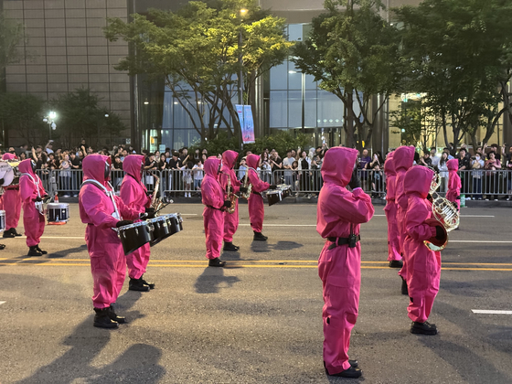A parade to celebrate the grand finale of Netflix's global hit series ″Squid Game″ (2021-) was held in central Seoul on June 28. The image features a marching band wearing the show's iconic Pink Guard costume. [KIM JI-YE]