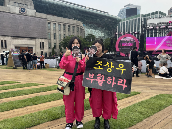 Lee Ju-won, left, and Lee Jin-ju, both wearing a Pink Guard costume from Netflix's ″Squid Game″ (2021-), pose for a photo during the show's grand finale event held at Seoul Plaza in central Seoul, on June 28. [KIM JI-YE]