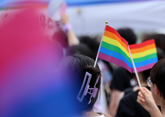 Participants hold up rainbow flags during a pride march in Daejeon on July 6, 2024. [YONHAP] 