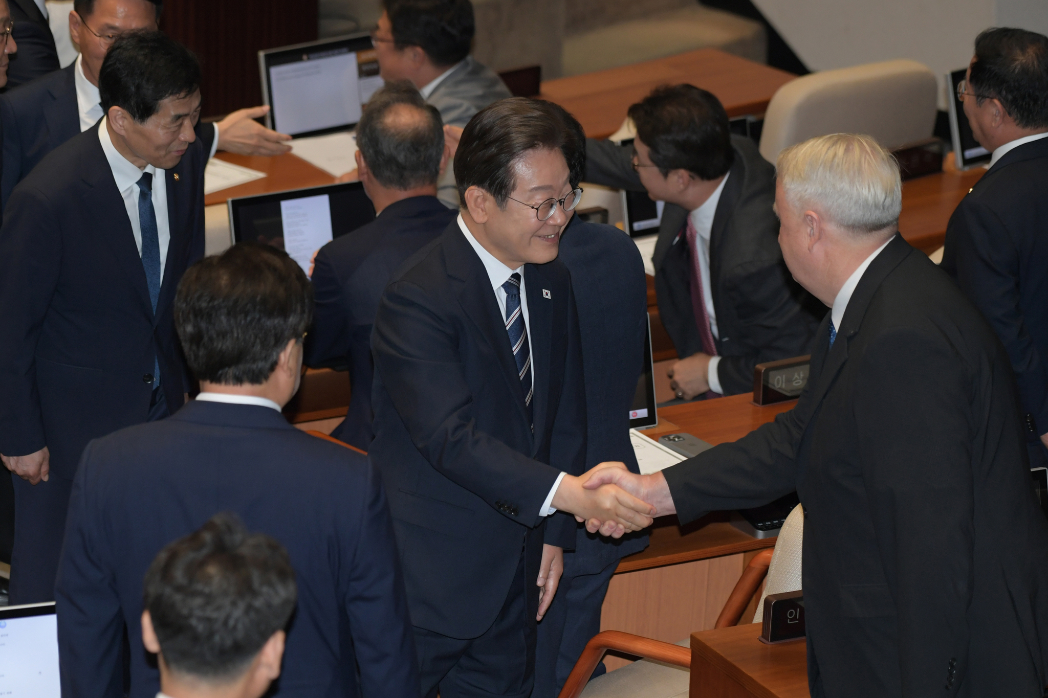 President Lee Jae Myung greets People Power Party lawmakers after delivering his first policy speech at the National Assembly in Yeouido, Seoul, on June 26, following the government's submission of its second supplementary budget proposal. [JOINT PRESS CORPS]