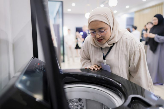 An attendee examines Samsung Electronics' AI Eco Bubble washing machine at the Southeast Asia Tech Seminar held in Bangkok, Thailand. [SAMSUNG ELECTRONICS]