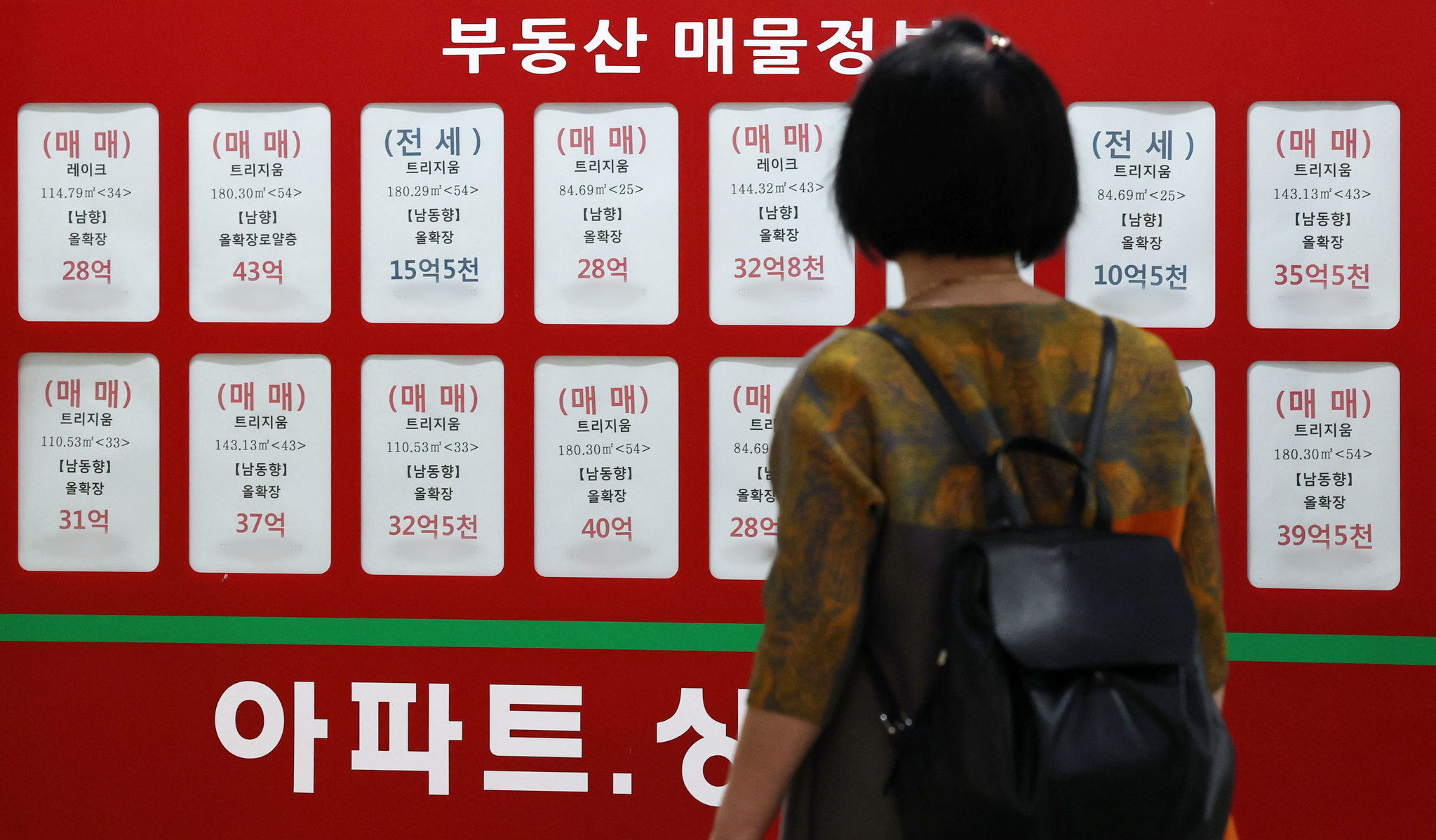 A passerby checks apartment listings near Jamsil apartment complexes at a real estate agency in Songpa District, southern Seoul, on June 29. [NEWS1]