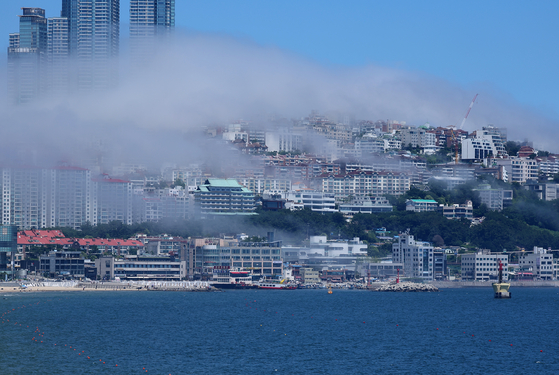 Thick sea fog blankets Dalmaji Hill in Haeundae District, Busan, on the afternoon of June 29. [YONHAP]