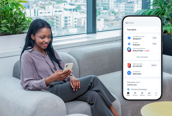 A woman uses a Toss application on her phone in this promotional photo provided by the payment services company. [TOSS]