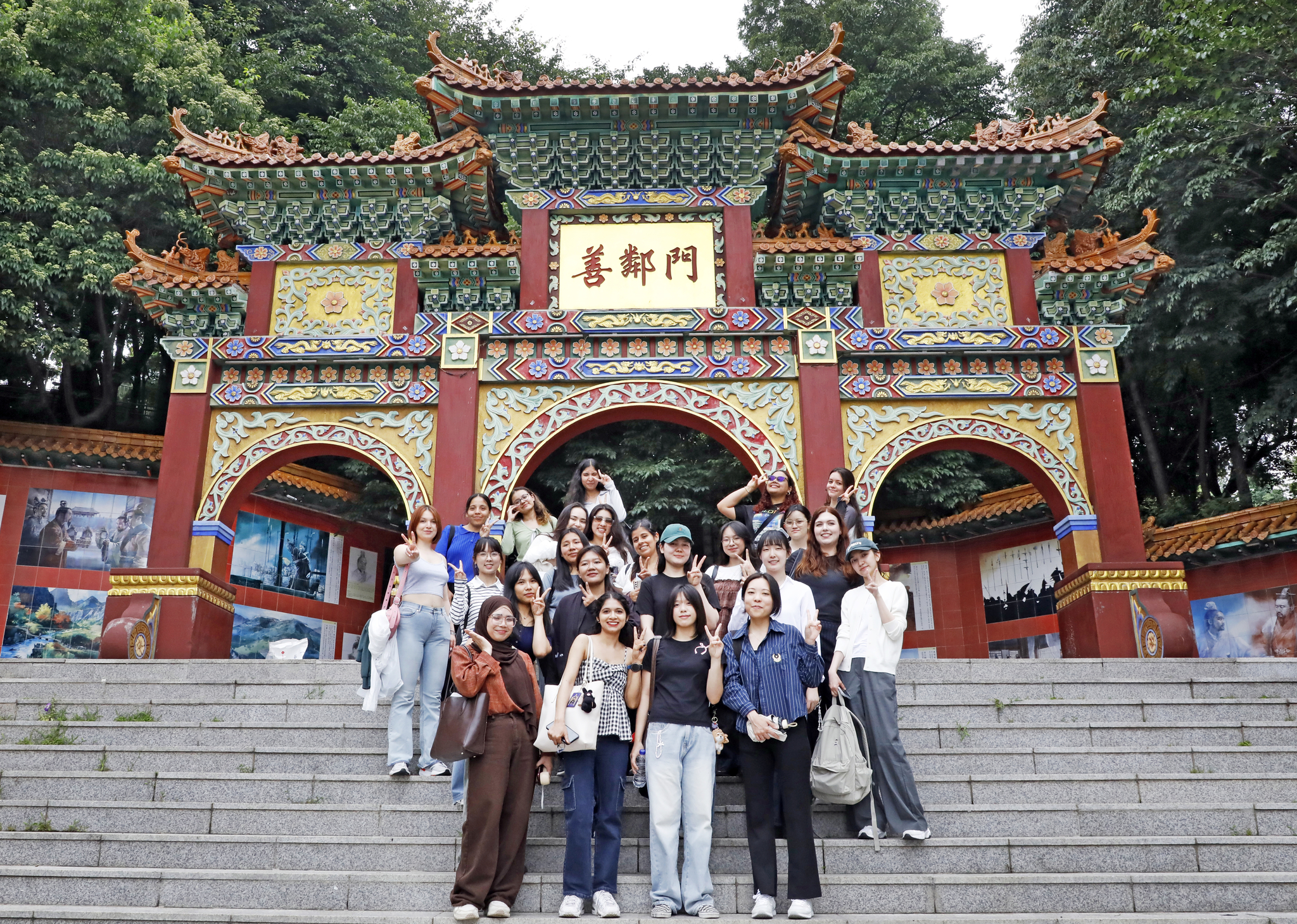 Students on June 27 take a photo infront of a paeru, or main gate, that connects the Jayu Park and Incheon Chinatown. [PARK SANG-MOON]