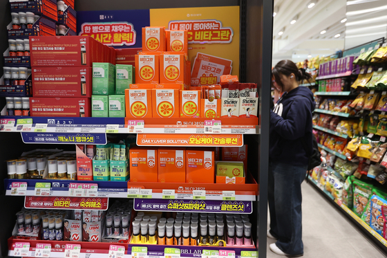 A customer examines health supplements at a CU convenience store in Jung District, central Seoul, on March 12. [YONHAP] 