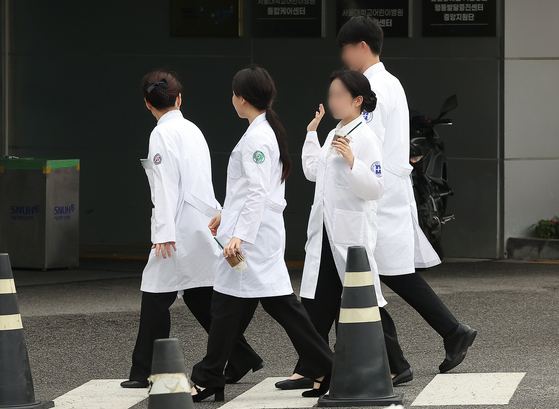 Medical school students walk across a road near a medical school in downtwon Seoul on June 25. [NEWS1]