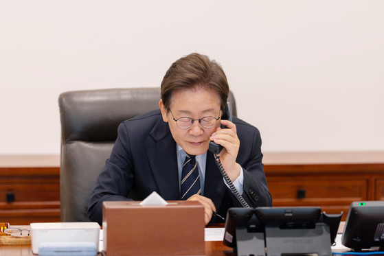 President Lee Jae Myung speaks on the phone to Singaporean Prime Minister Lawrence Wong at the presidential office in Yongsan, central Seoul, on June 30. [PRESIDENTIAL OFFICE] 