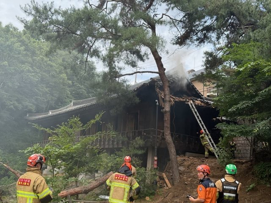 Fire authorities work to put out a fire at Seongbuk-dong Garden, a designated cultural heritage site in Seongbuk District, northern Seoul, on June 30. [KOREA HERITAGE SERVICE]